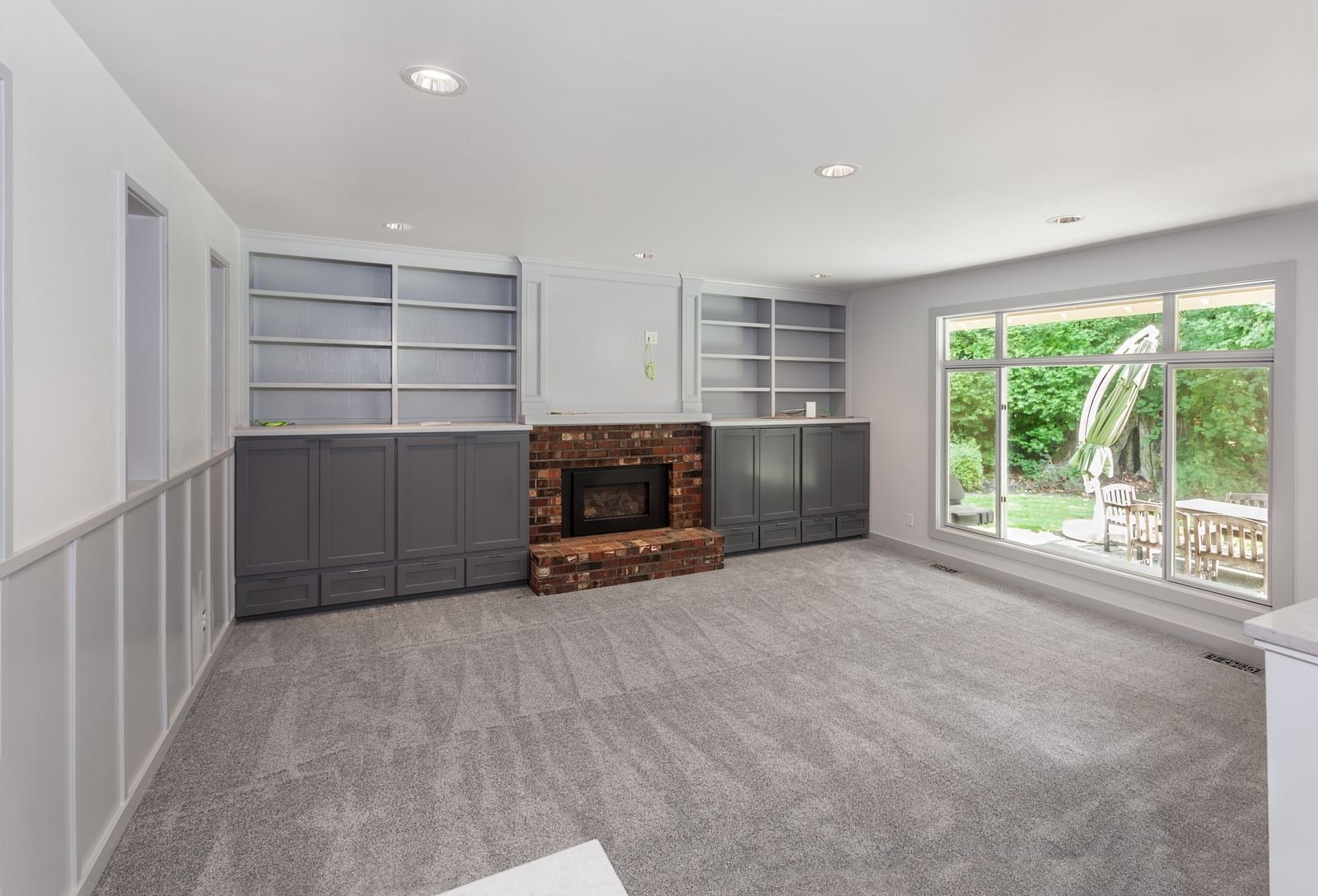 Freshly cleaned grey carpet in a living room with a brick fireplace